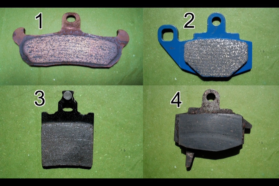 Set of ceramic brake pads arranged on a workbench next to a brake rotor in an automotive shop