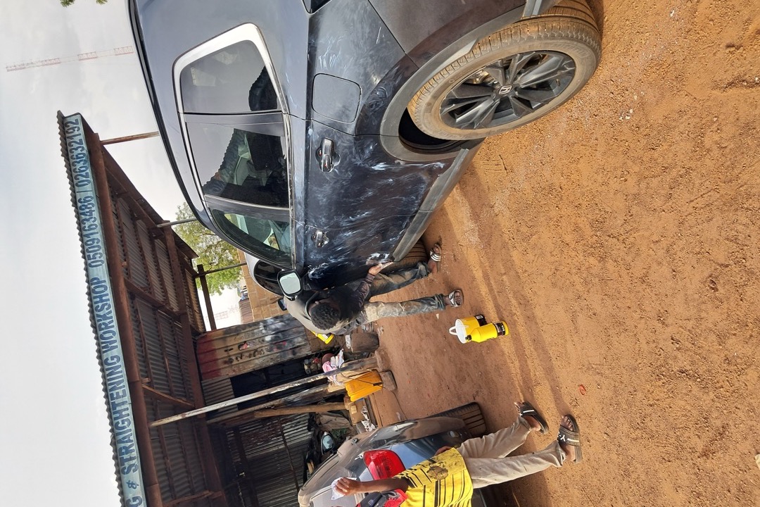 Detailer applying paint sealant to a glossy black car hood with a foam applicator pad