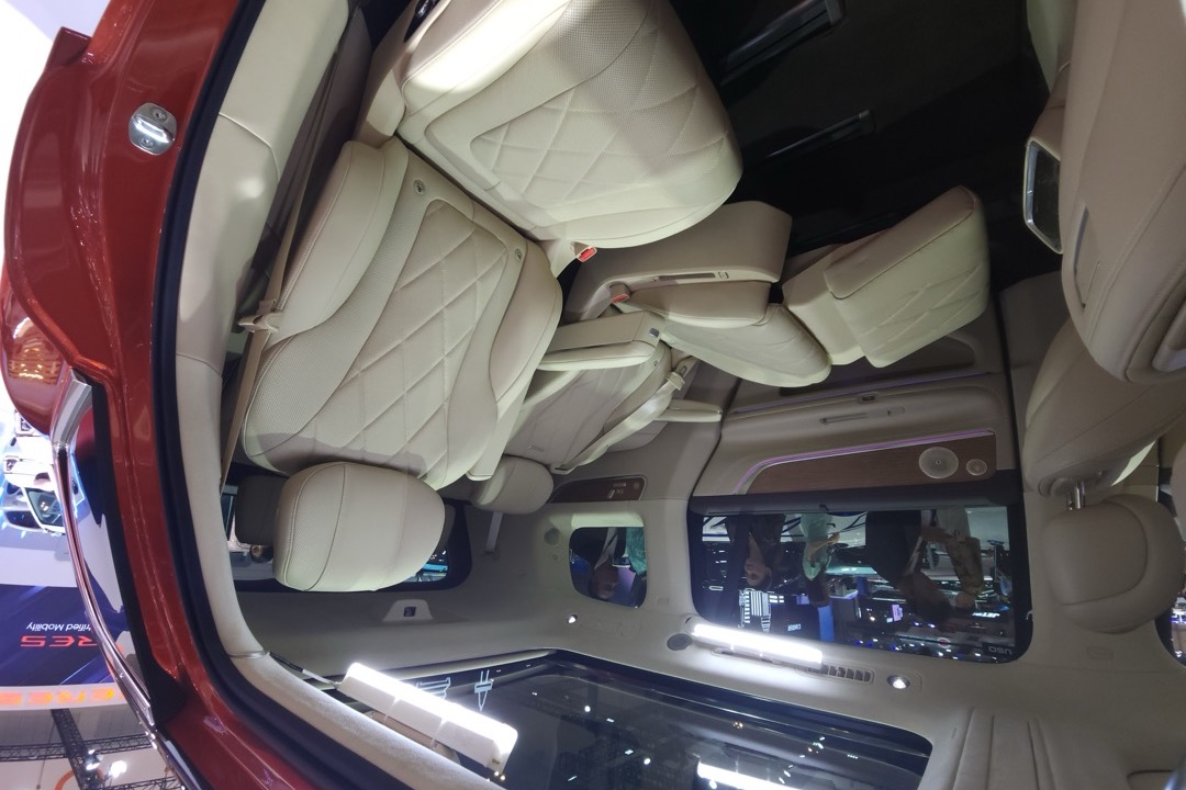Backseat car organizer with multiple storage pockets and a tablet holder strapped to the back of a front seat
