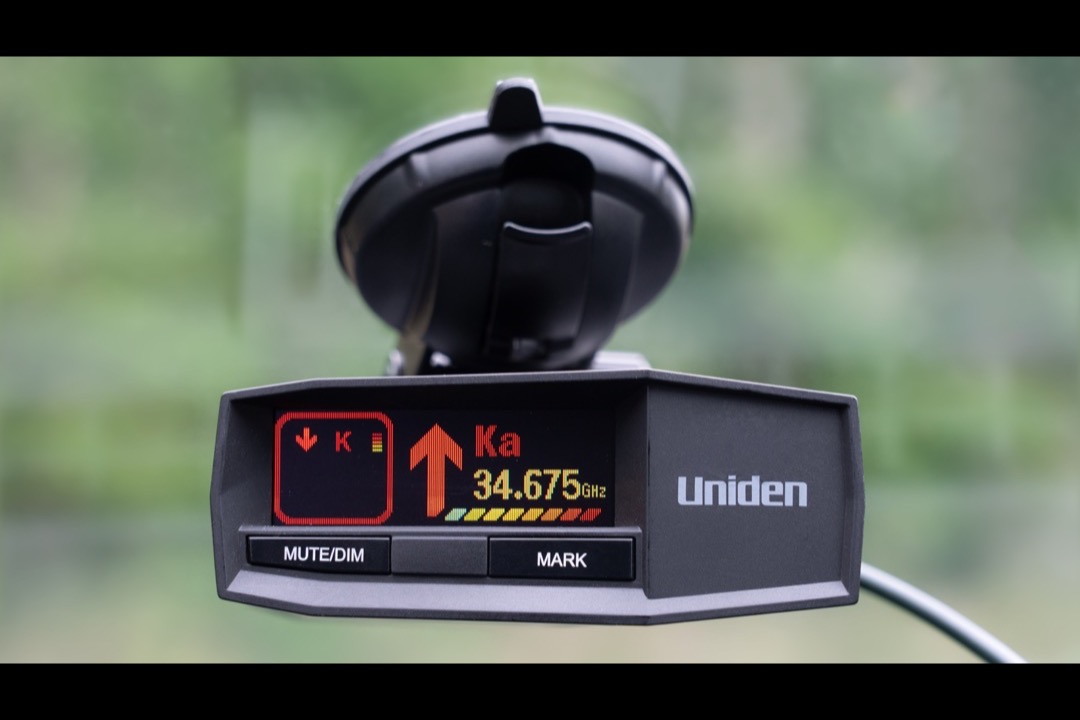 Uniden radar detector mounted on a car windshield