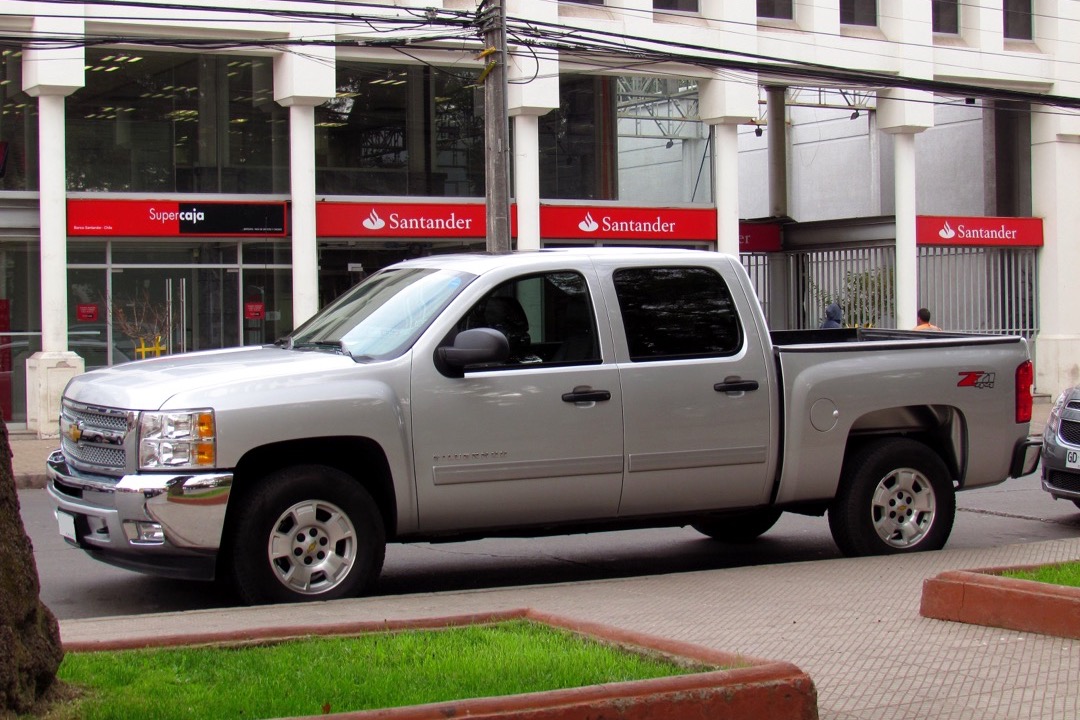 Black 6-inch wide running boards installed along the rocker panels of a lifted four-door pickup truck