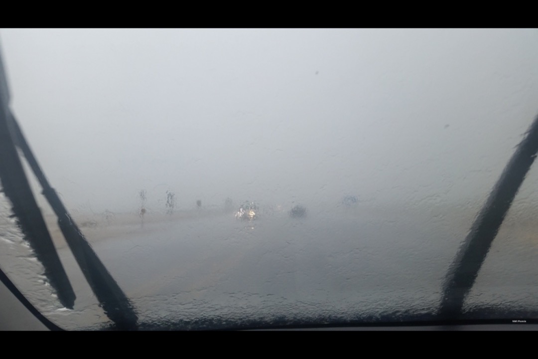 Person holding a new windshield wiper blade ready for installation on a vehicle