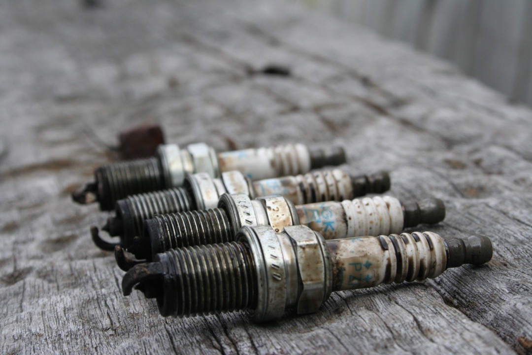 Close-up of automotive spark plugs showing electrode tips and ceramic insulators