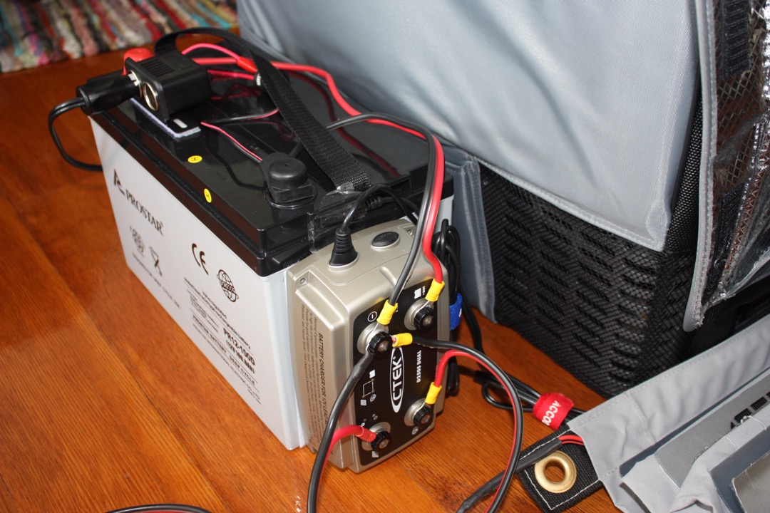A car battery connected to a smart CTEK maintenance charger, illustrating how a battery maintainer keeps a 12-volt battery healthy between drives