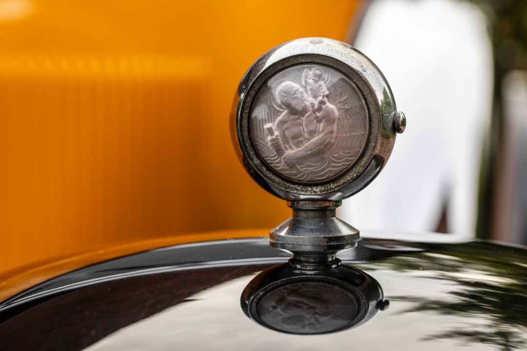 A beautifully detailed classic car with a glossy, polished paint finish showing deep reflections