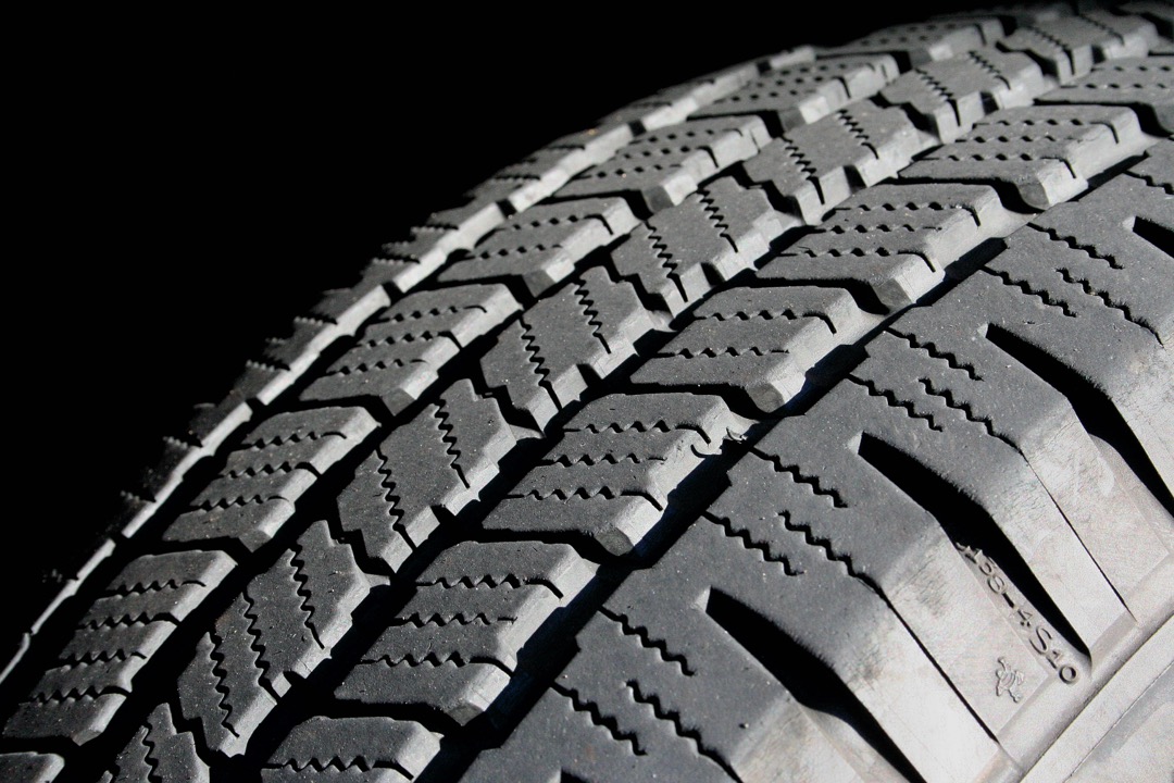 Close-up of a new car tire mounted on a wheel showing detailed tread pattern